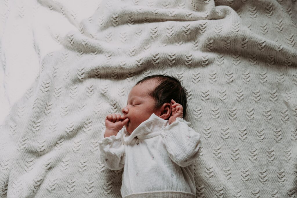 Newborn baby ligt op kleedje te slapen