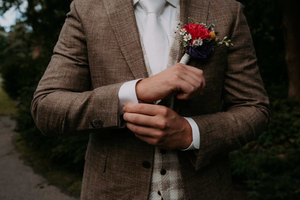 Handen van bruidegom zitten aan manchetknopen