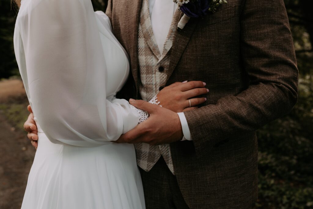 Bruid en bruidegom houden elkaar vast