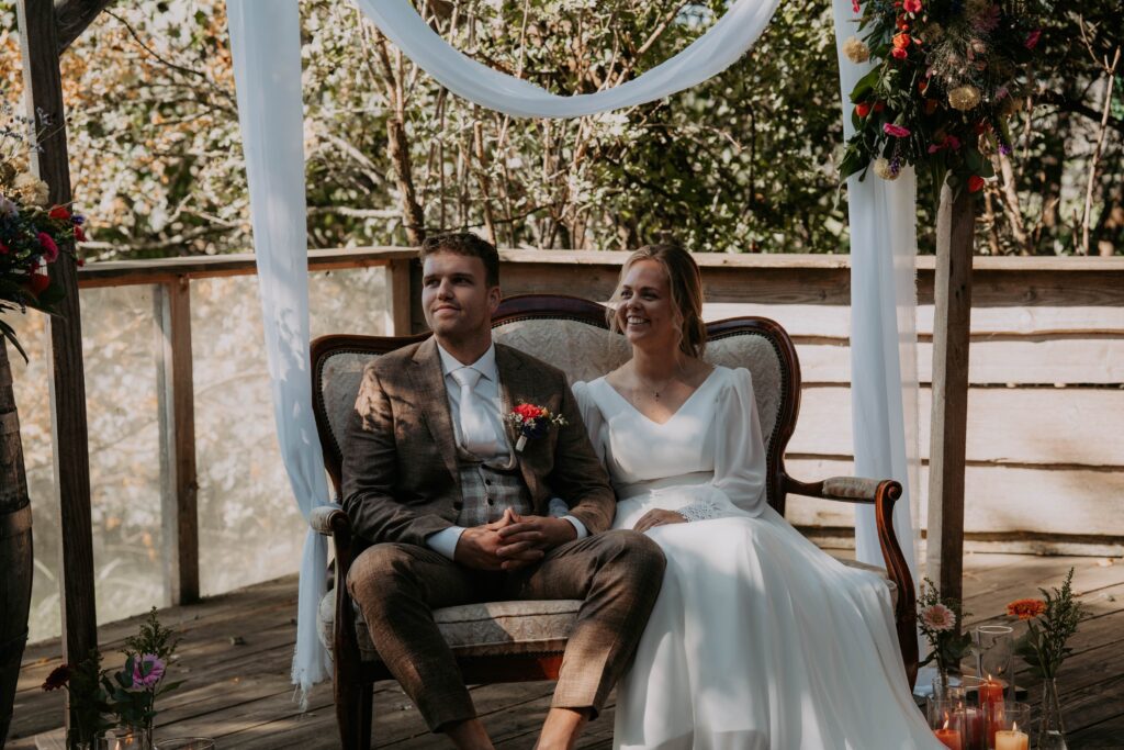 Bruidspaar zit naast elkaar en lacht