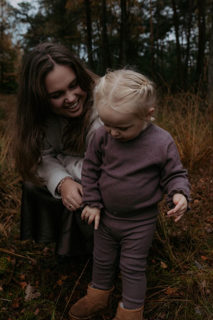 meisje in bos in Ede met mama kijkt naar het mos