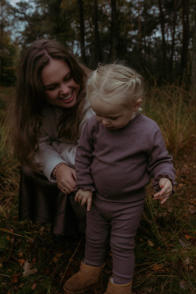 meisje in bos in Ede met mama kijkt naar het gras
