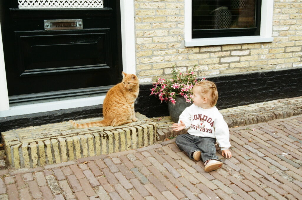 Meisje zit naast rode poes